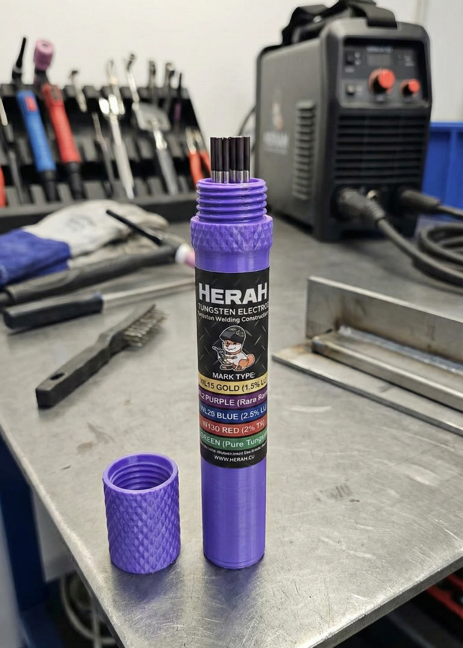 Purple cylindrical product with tig tungsten 'HERAH' branding on a workshop table.